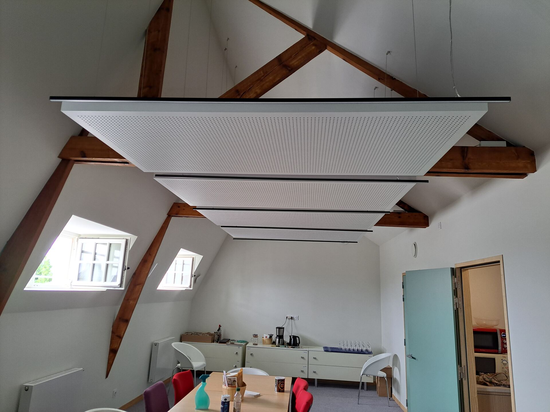 Combles aménagés avec plafond acoustique et charpente apparente